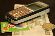 Will the cell phone supplant cold, hard <br>cash? Photo by <a href="http://flickr.com/photos/whiteafrican/2620808649/">Eric Hersman</a> (<a href="http://creativecommons.org/licenses/by/2.0/deed.en">CC</a>).
